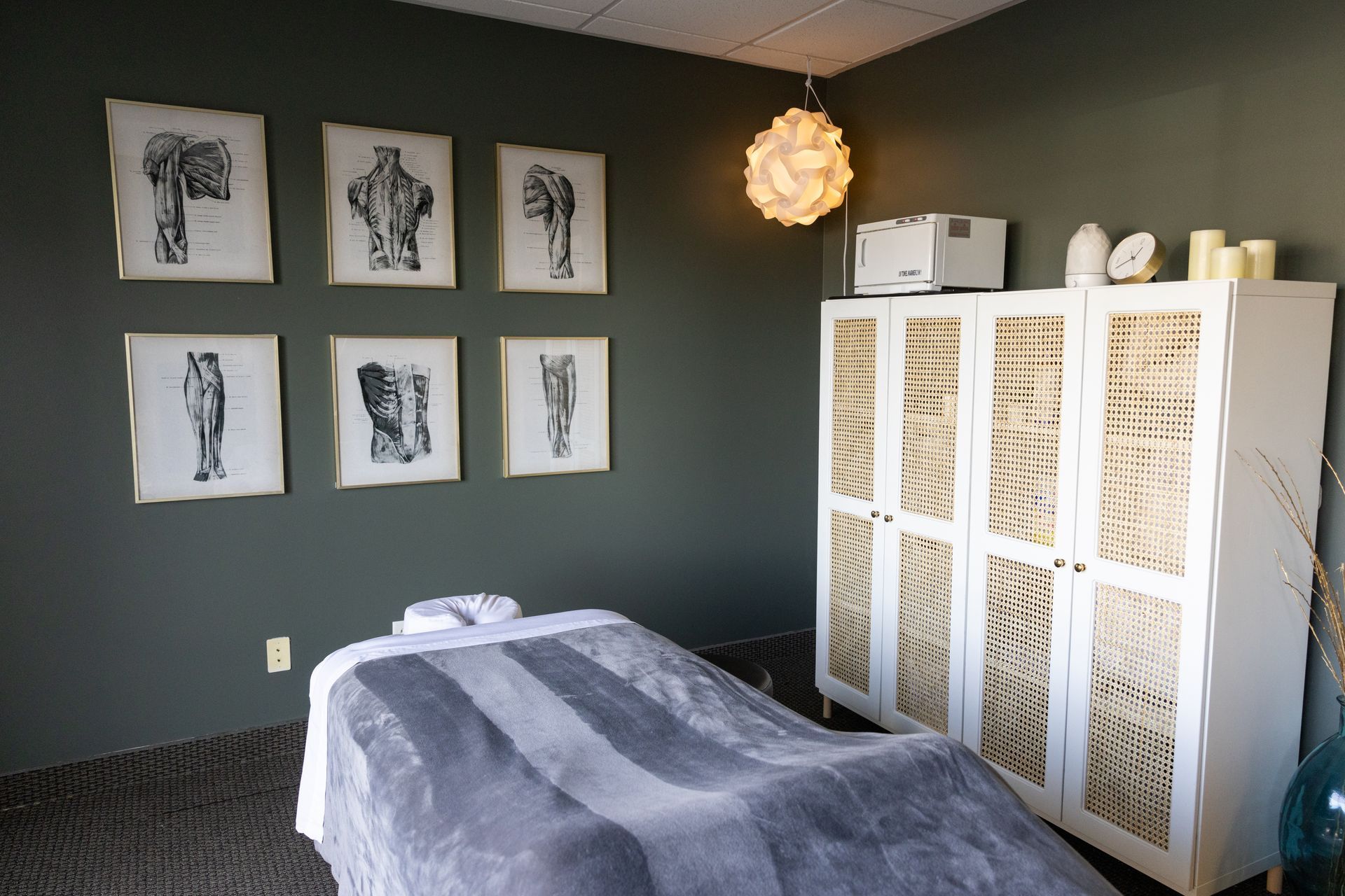 Massage room with table, chair, and mirror