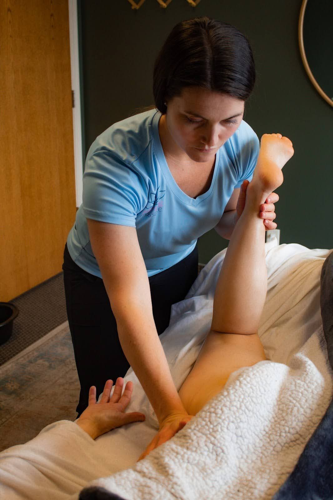 Therapist stretching a client's leg during an injury massage session